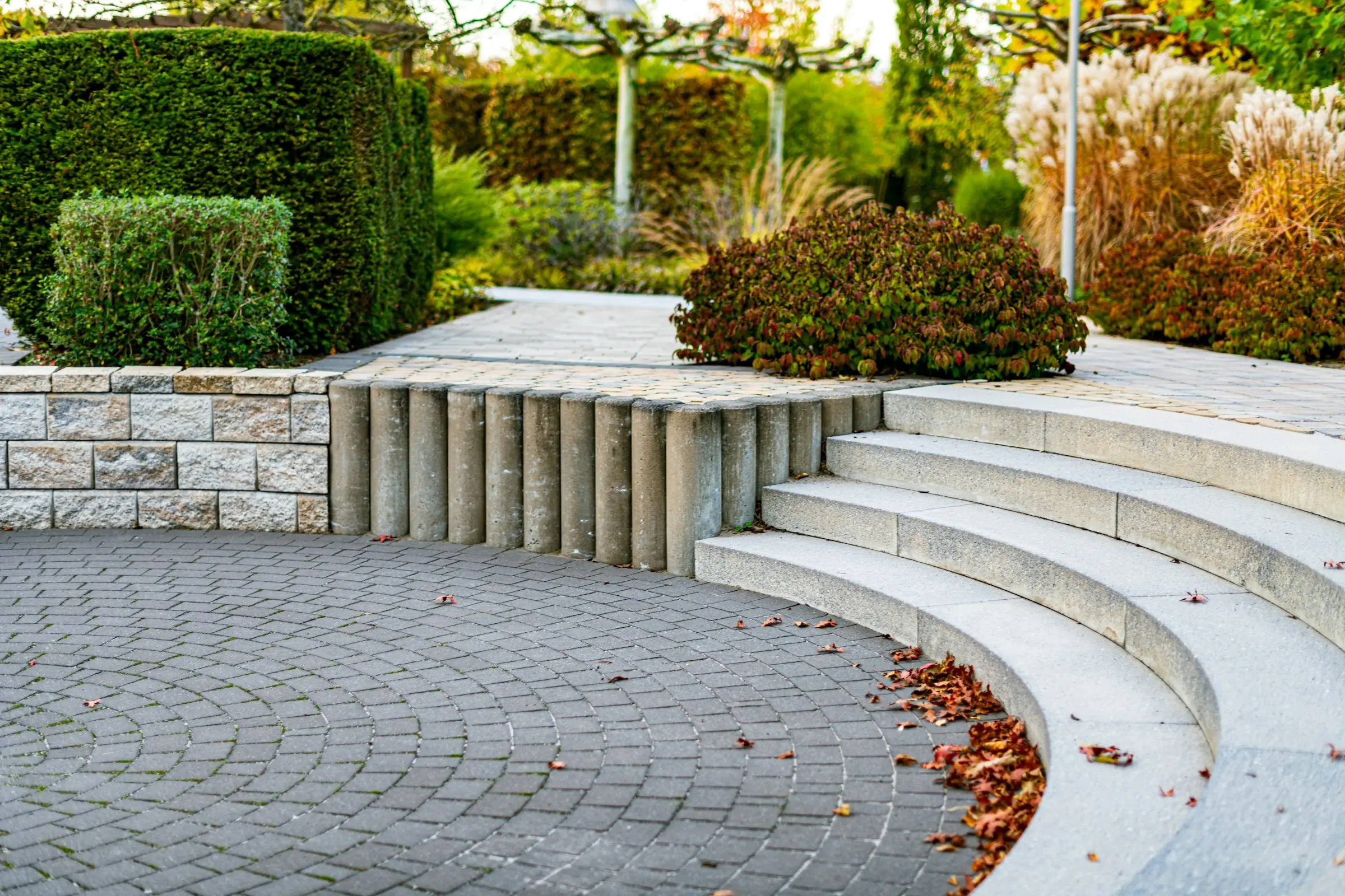 Stone staircase and retaining walls lit at dusk in a mature garden