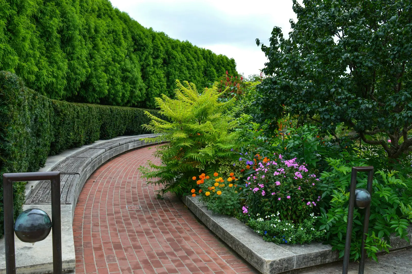 Brick garden path lined with flowers and shrubs